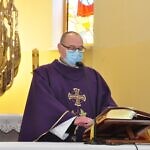 Zdjęcie Księdza Józefa Kruka stojącego przy ołtarzu i trzymającego mszał