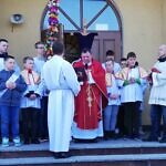 Zdjęcie księdza stojącego przed kościołem z procesją wejścia