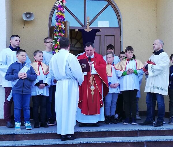 Zdjęcie księdza stojącego przed kościołem z procesją wejścia